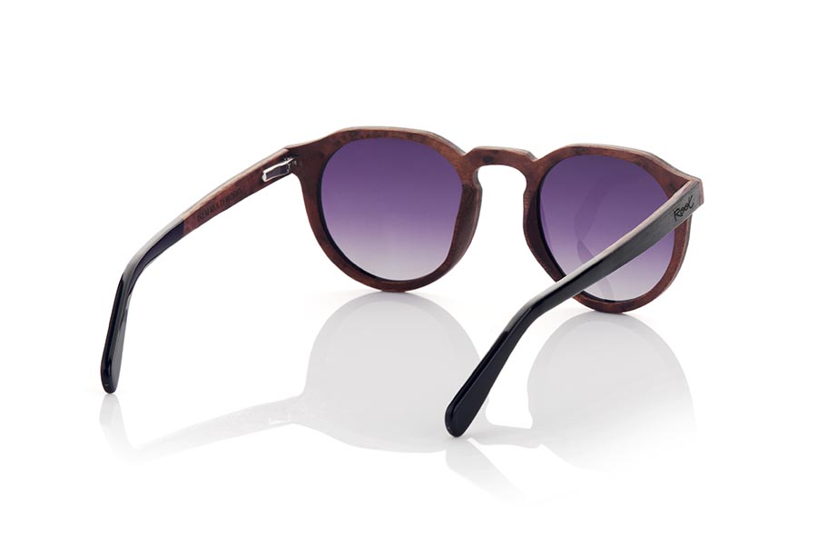 Wood eyewear of Ebony IREM. IREM wooden sunglasses combine elegance and style. They are made entirely with a frame made of laminated EBONY wood on the upper part and Burr wood with a marbled appearance on the lower part and on the inside, while the temples are made of ebony wood on the outside and Burr wood on the inside. inside. It is rounded at the bottom and angular at the brow, making it suitable for both men and women. It is available in two gradient lens colors: brown and grey.
The finish on these sunglasses makes them unique and elegant, perfect for those looking for something different in their fashion accessories. In addition, being made of laminated wood, they are resistant and durable, and the combination of different wood tones adds a touch of style and originality. Front measurement: 141x51mm Caliber: 49 for Wholesale & Retail | Root Sunglasses® 